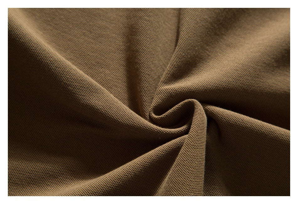 Close-up of brown textured polo fabric gathered into soft folds.