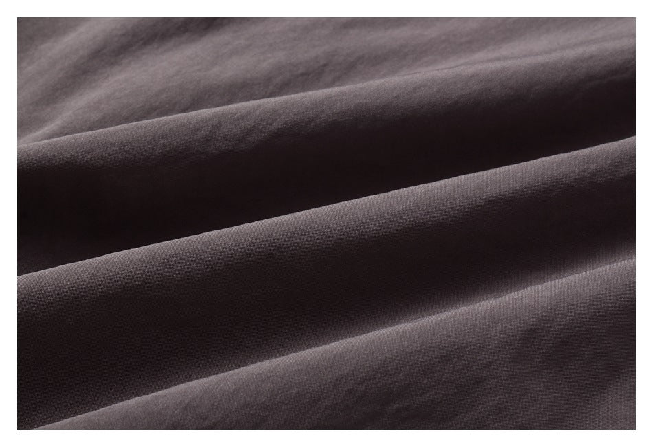 Extreme close-up of the dark gray jacket fabric, showing its surface texture and folds.