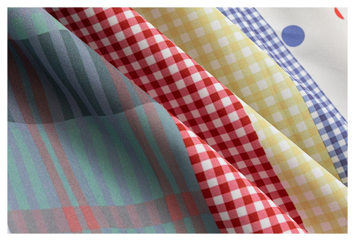 Fabric close-up of teal plaid, red and yellow gingham, blue checks, and a white panel with colored dots.