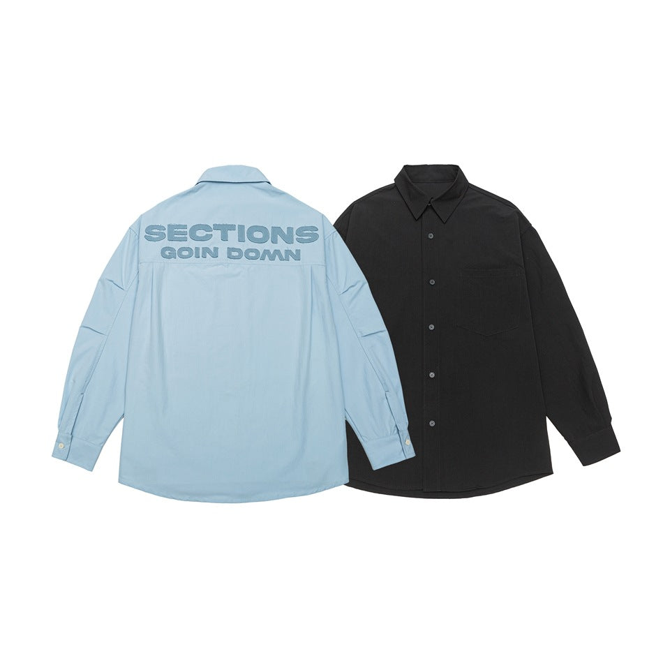 Light blue shirt shown from the back with blue lettering, beside a black shirt shown from the front.