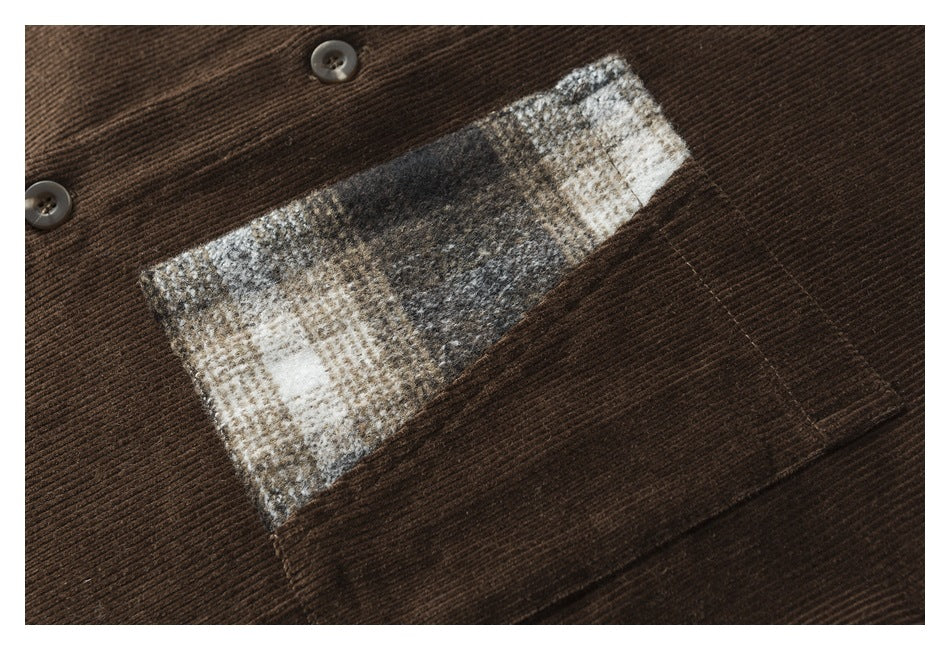 Close-up of the shirt's gray, cream and brown plaid chest pocket against brown corduroy.