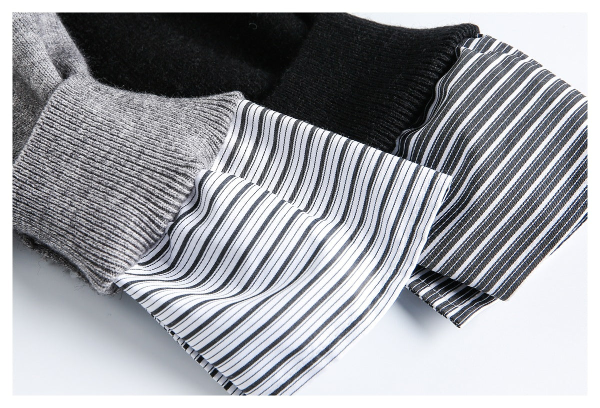 Close-up of gray and black sweater cuffs with striped shirt fabric extending below the ribbed knit.