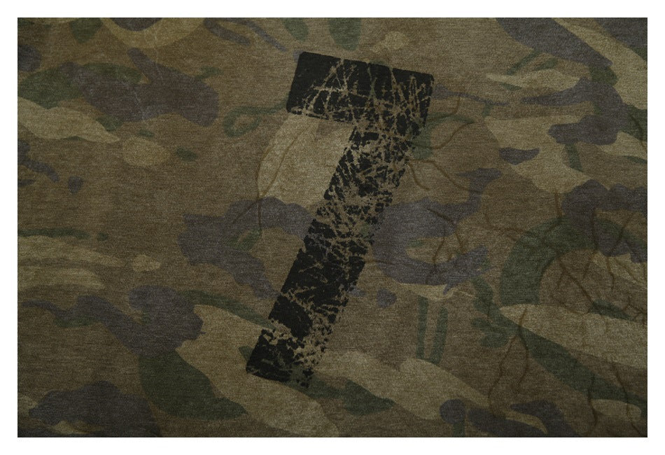 Close-up of camouflage fabric with a distressed black vertical graphic.