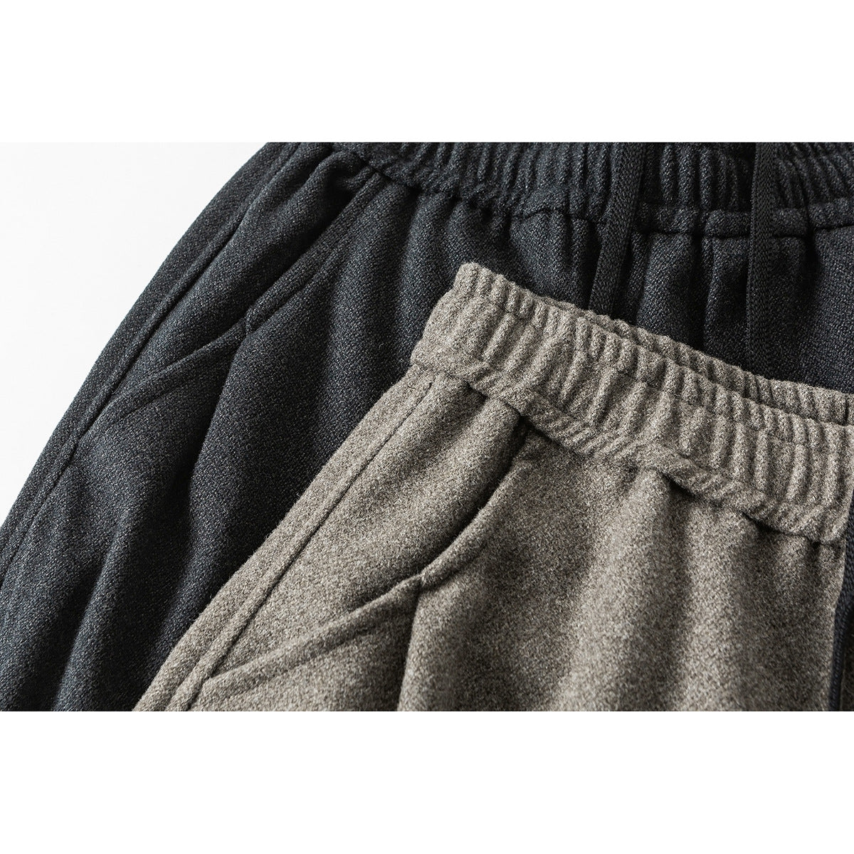Close-up of elastic waistbands on charcoal and taupe wide-leg pants.