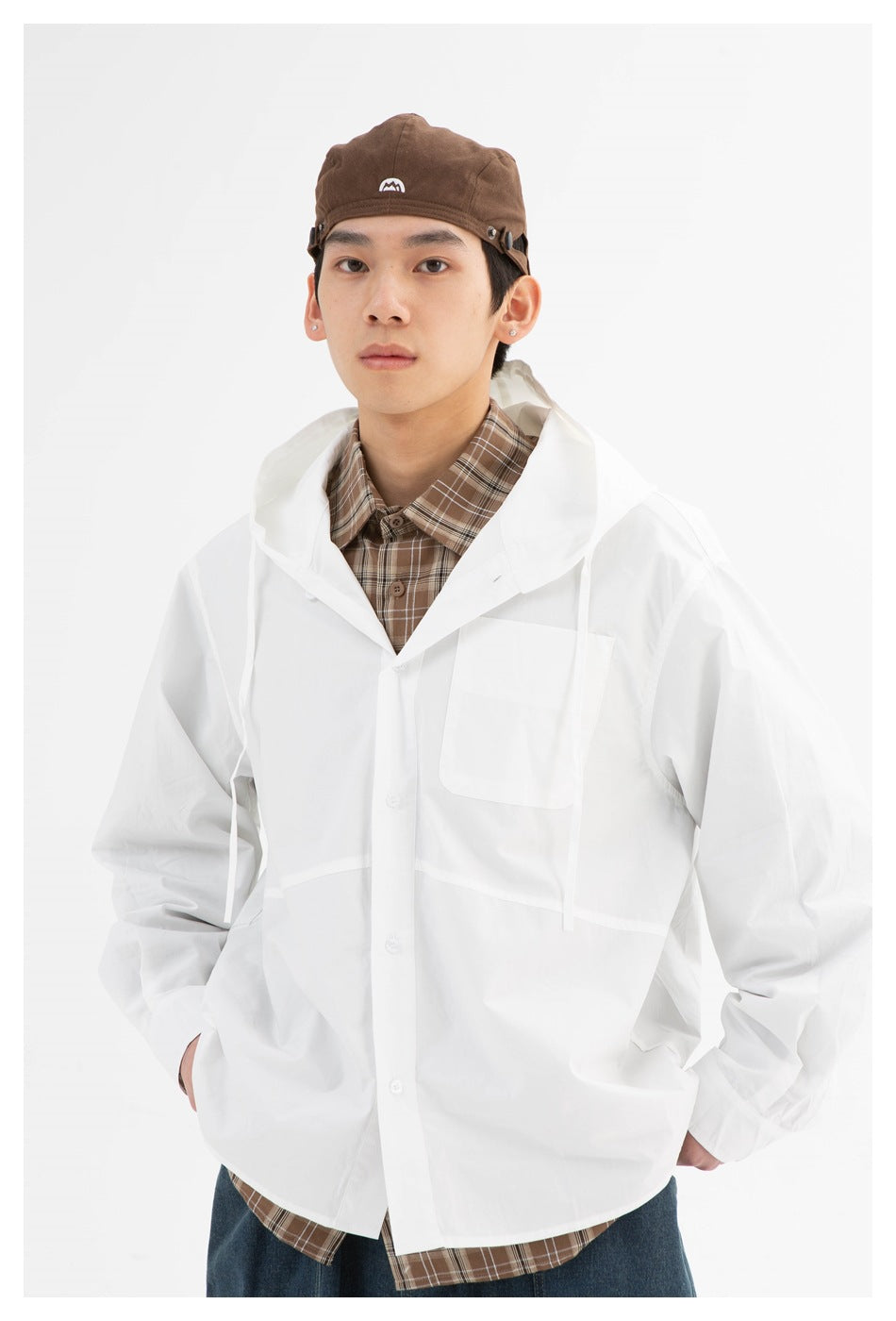 Model wearing a white hooded button-front jacket with a chest pocket over a brown plaid shirt.