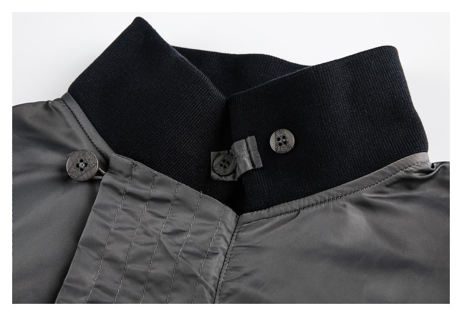 Close-up of a gray jacket's black ribbed collar, button closures, and stitched front placket.