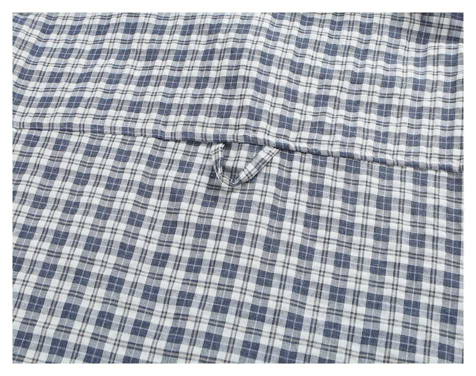 Close-up of a plaid shirt's back yoke seam and small hanging loop.
