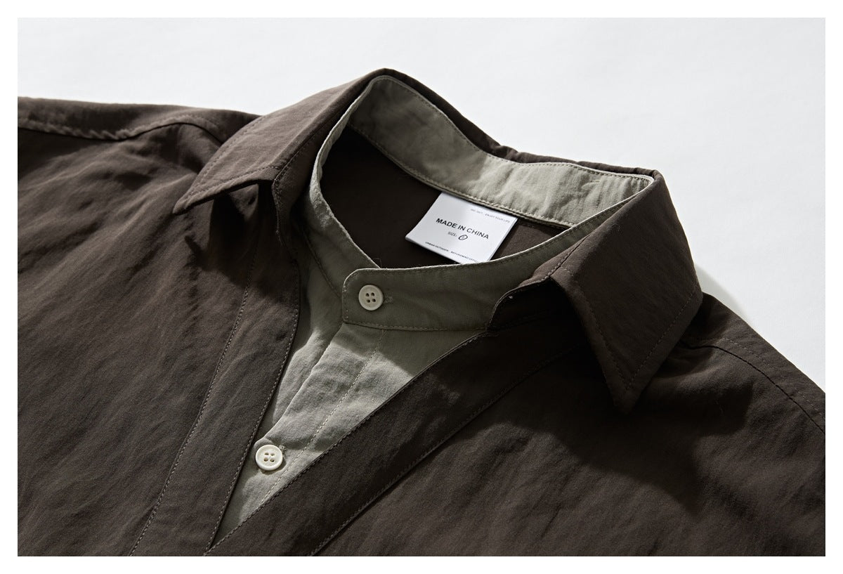Close-up of a dark brown shirt collar, gray-green inner collar and placket, and white buttons; neck label reads “Made in