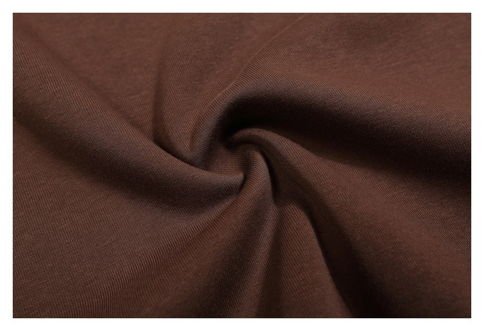 Macro view of brown fabric gathered into folds, showing its surface texture.