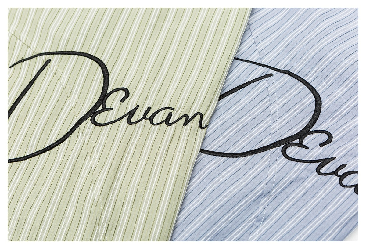Green and blue striped fabric colorways with large black cursive “Dream” embroidery.