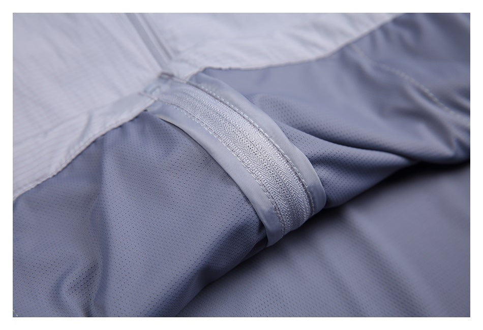 Close-up of a stitched seam joining light gray pinstriped fabric to darker gray perforated lining.