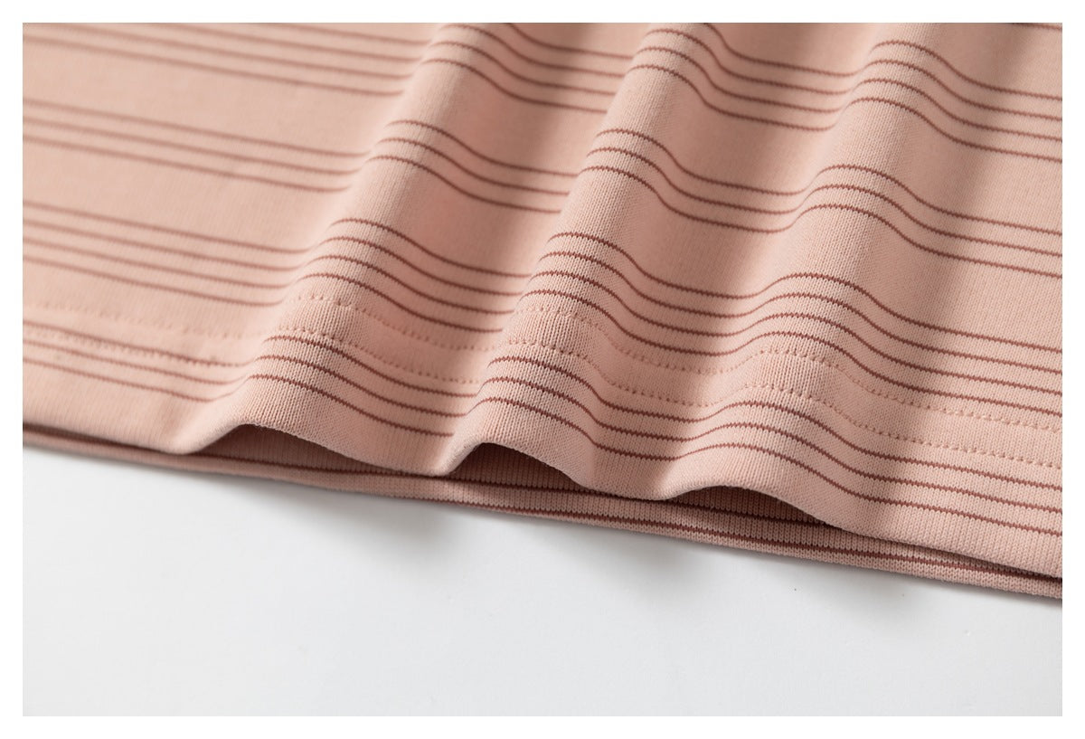 Close-up of the wavy hem and thin brown stripes on a pink garment.