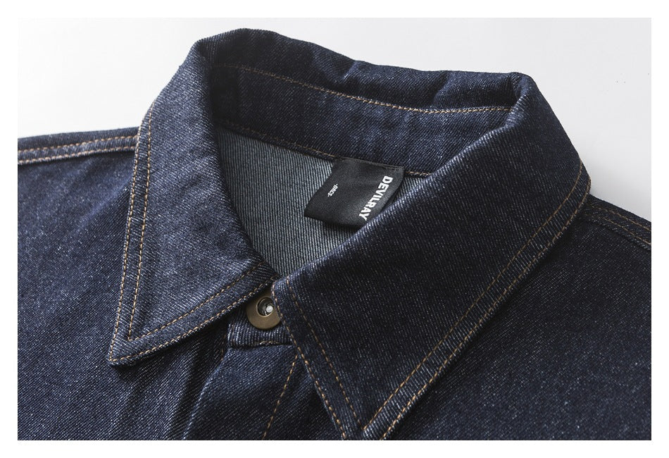 Close-up of the dark denim shirt's pointed collar, contrast stitching, top button and neck label.