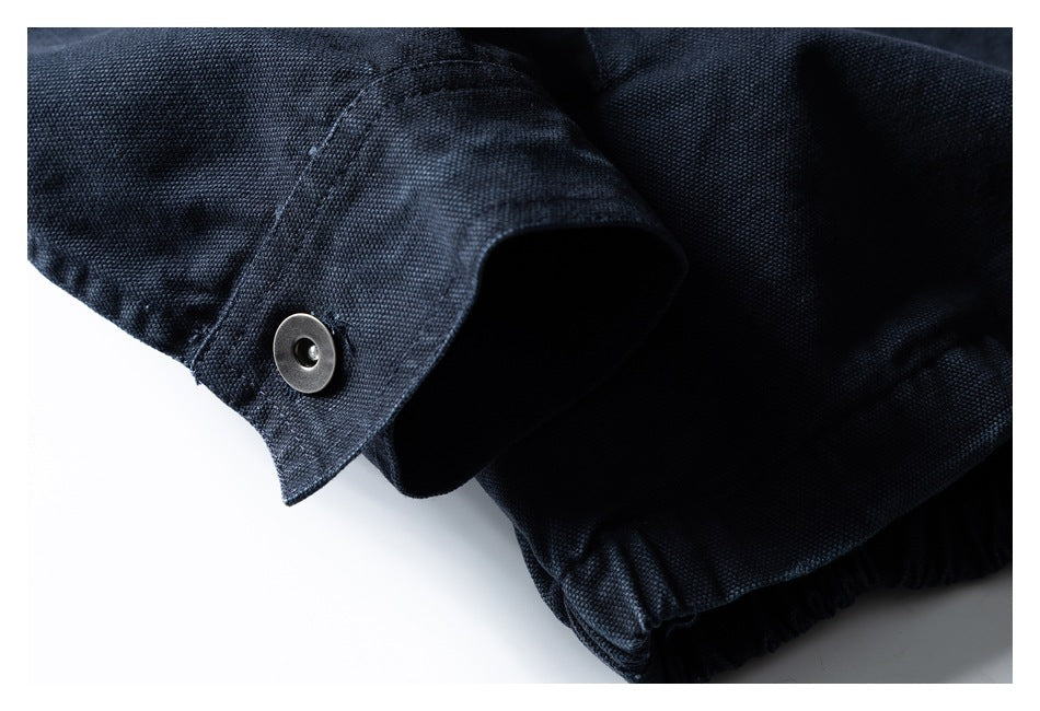 Close-up of a dark navy jacket sleeve cuff with a metal snap and gathered hem visible.