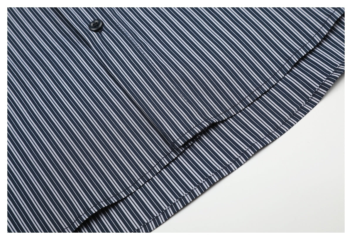 Close-up of the curved, stitched hem on a navy shirt with narrow white stripes.
