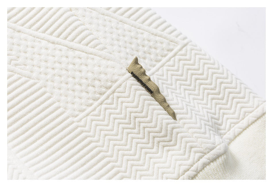 Close-up of cream quilted fabric with a small sewn label bearing English text.