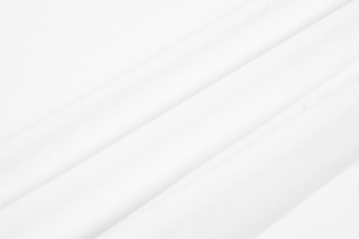 Close-up of white fabric with subtle diagonal ribbed texture and soft folds.
