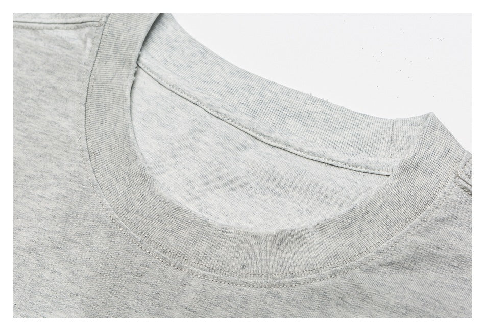 Close-up of the light gray heather T-shirt's ribbed crew neckline and shoulder seam.