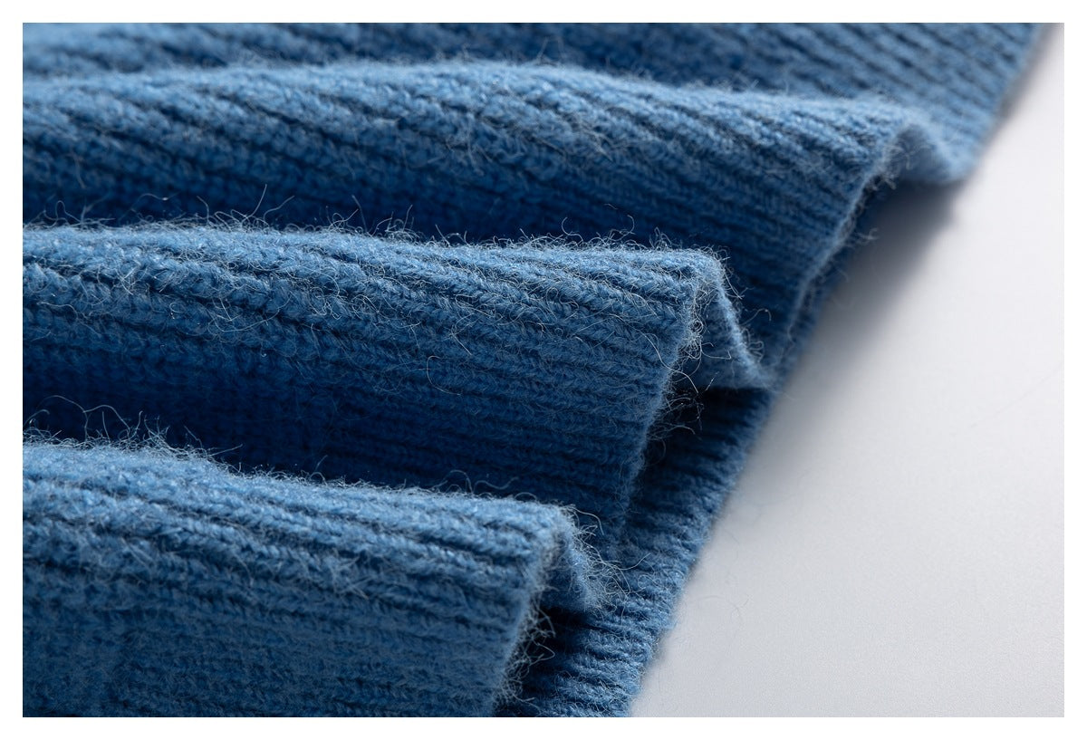 Close-up of layered ribbed cuffs on the blue knitted sweater.