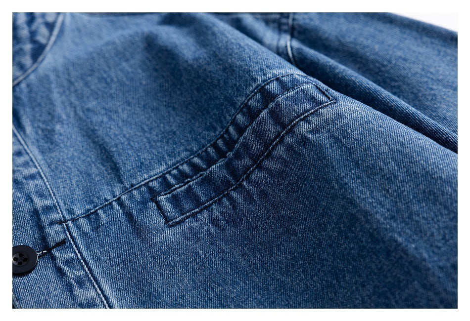 Close-up of a stitched pocket opening and seams on blue denim.
