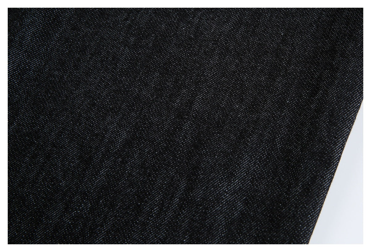 Close-up showing the dark diagonal weave and texture of black denim.