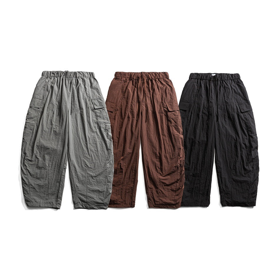 Front view of loose cargo pants in gray, brown, and black, shown side by side.