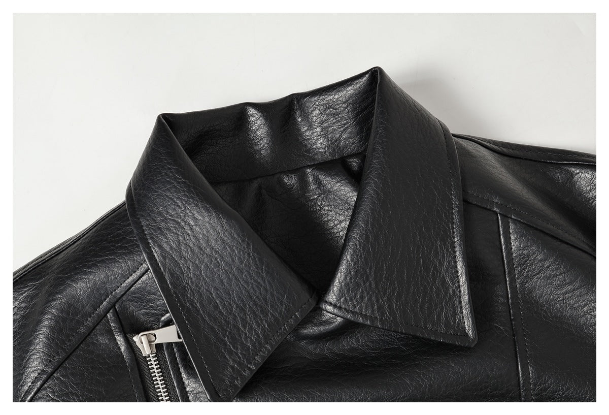 Close-up of a black jacket's wide notched collar, textured surface, shoulder seam and silver zipper.