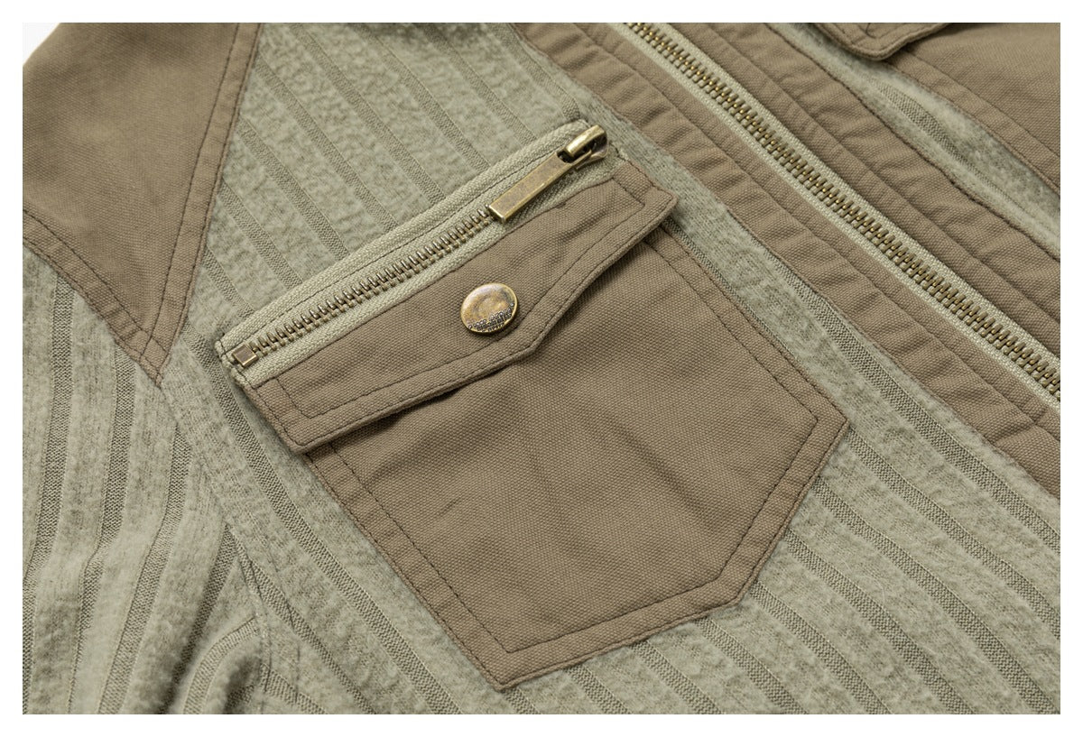 Close-up of a taupe patch pocket with a horizontal metal zipper and button on striped jacket panels.