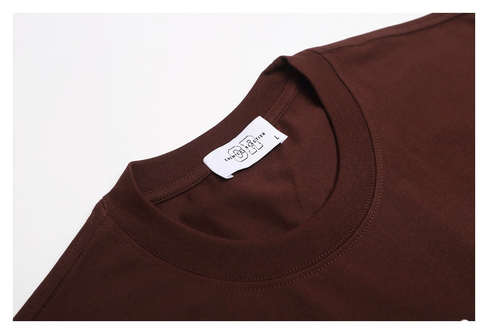 Close-up of the dark brown T-shirt's ribbed crew neck and white inside label.