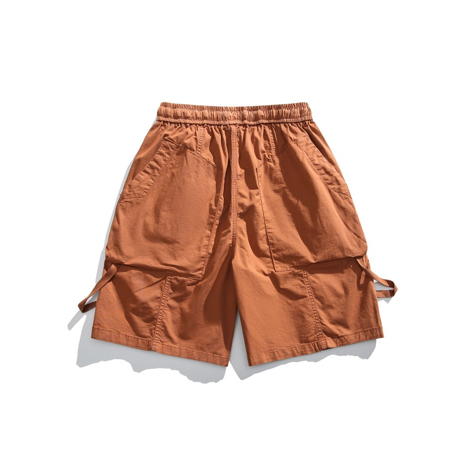 Rust orange cargo shorts laid flat, showing an elastic waistband and large front pockets.