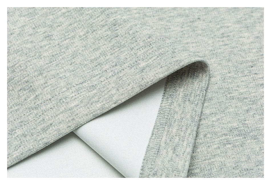 Close-up of light gray heathered fabric folded back to show a stitched edge and pale reverse side.