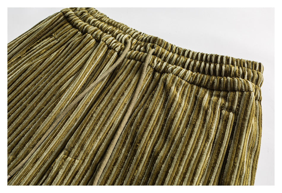 Close-up of olive and tan striped corduroy pants showing the gathered elastic waistband.