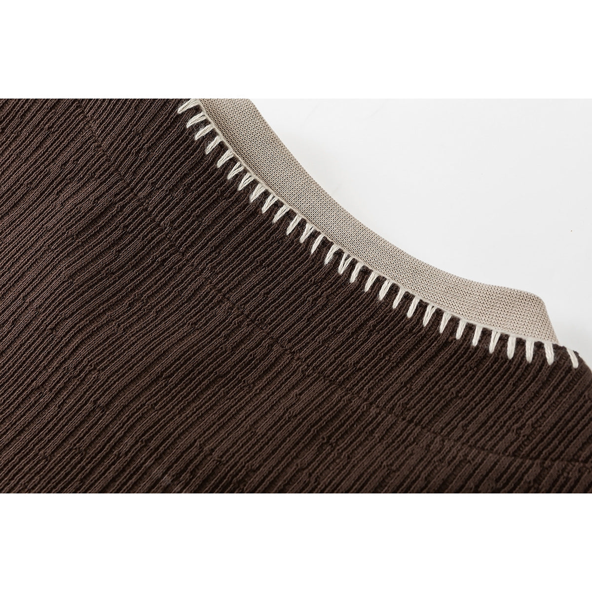 Close-up of a brown ribbed top's beige neckline binding and contrasting blanket stitching.