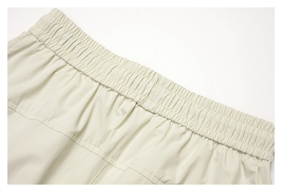 Close-up of a cream garment's gathered elastic waistband and stitched seam.