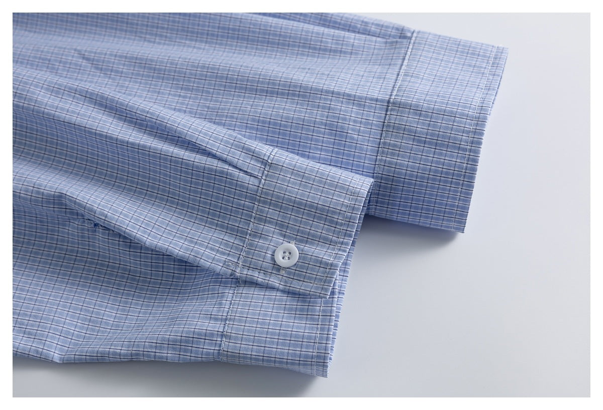 Close-up of a blue-and-white check shirt sleeve cuff with a white button.