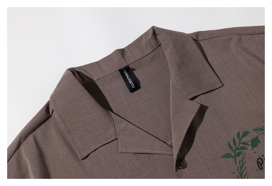 Close-up of a taupe shirt's notched collar, front button, and black neck label.