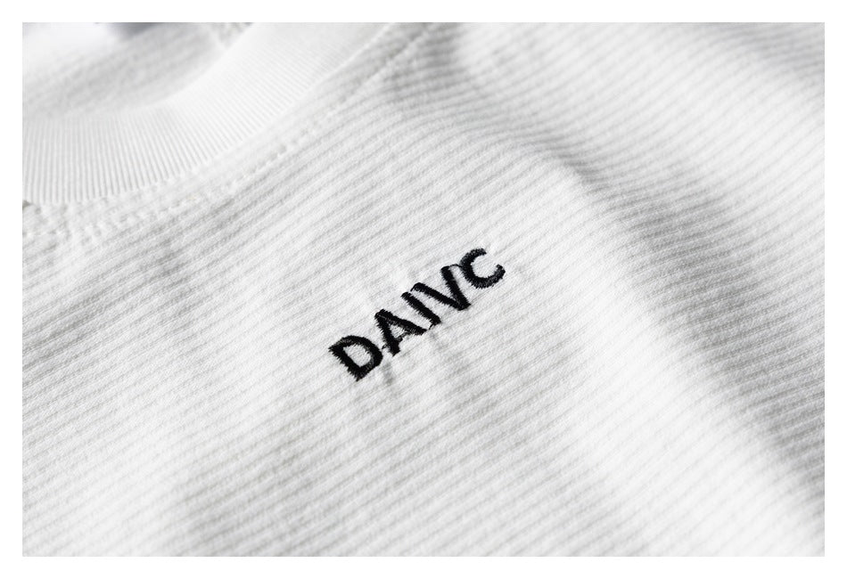 Black DANC embroidery on white ribbed knit fabric.
