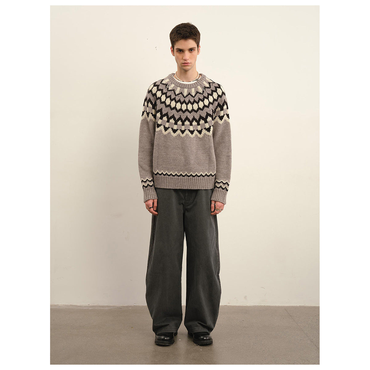 Front full-length view of a model wearing a taupe gray sweater with a black and cream geometric yoke.