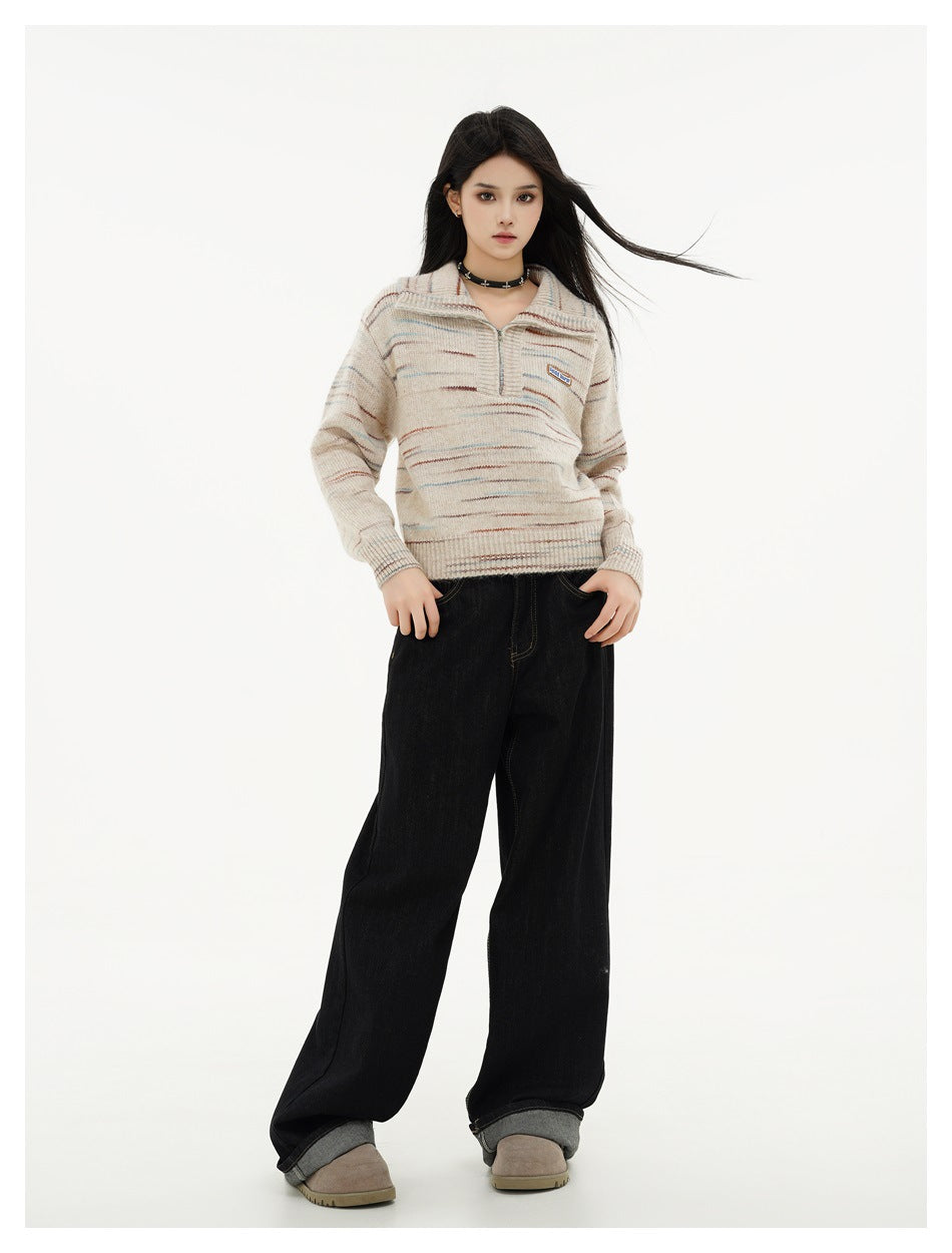 Full-length model wearing a beige multicolor-striped collared pullover with wide-leg black jeans.