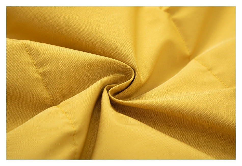 Close-up of mustard-yellow garment fabric gathered to show its surface and stitching.