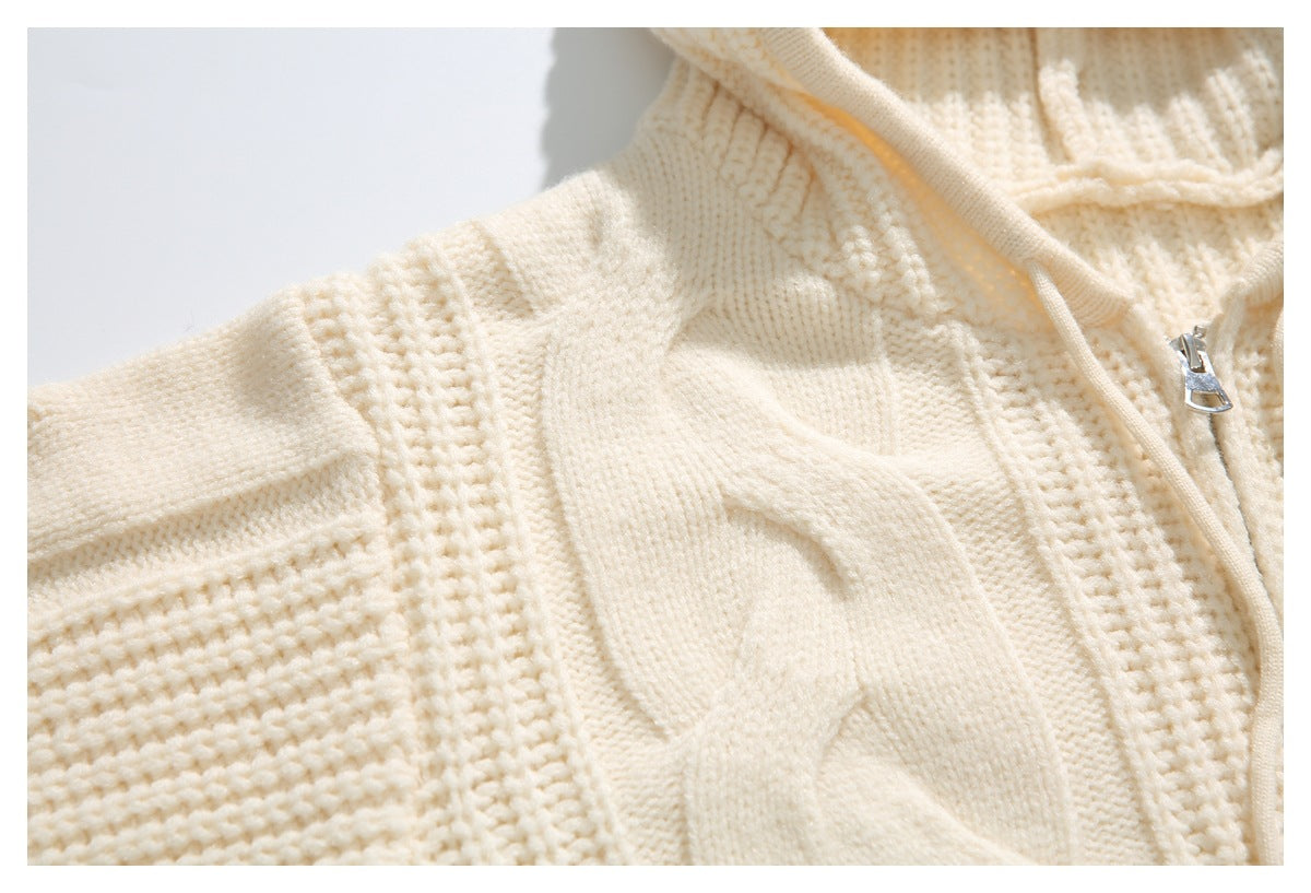 Close-up of an ivory cable-knit cardigan with a front zipper, collar edge, and textured sleeve.