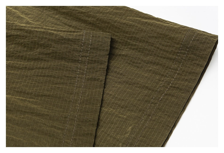 Close-up of an olive jacket sleeve with a stitched panel and cuff.