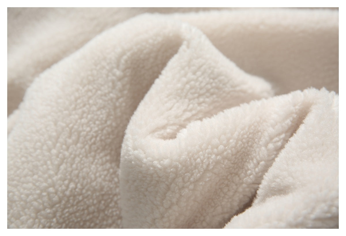 Macro view of the cream jacket's textured fleece fabric.