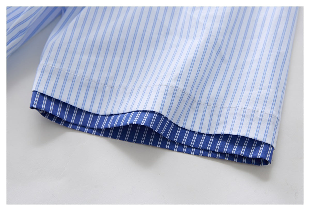 Close-up of the hem of a white shirt with blue stripes, revealing a darker blue striped inner layer.