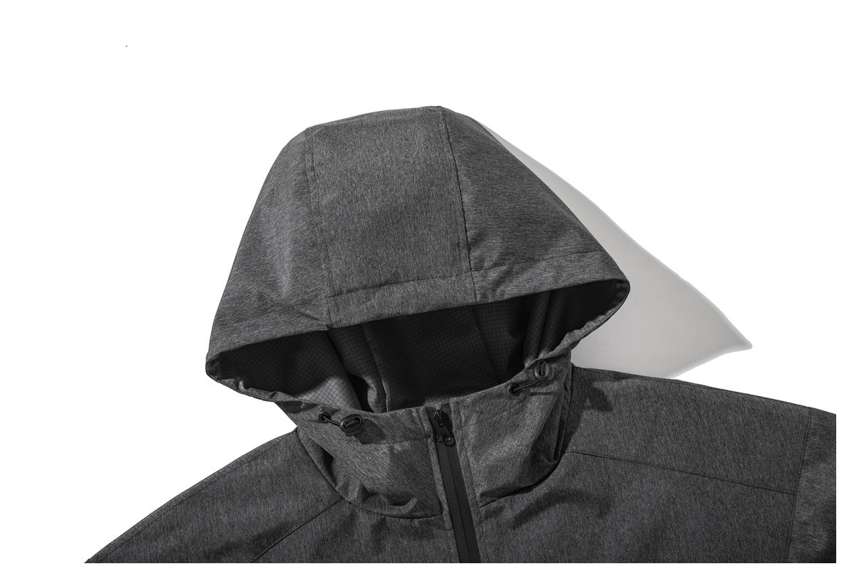 Close-up of a charcoal gray hooded jacket with black grid lining, drawcords and a front zipper.