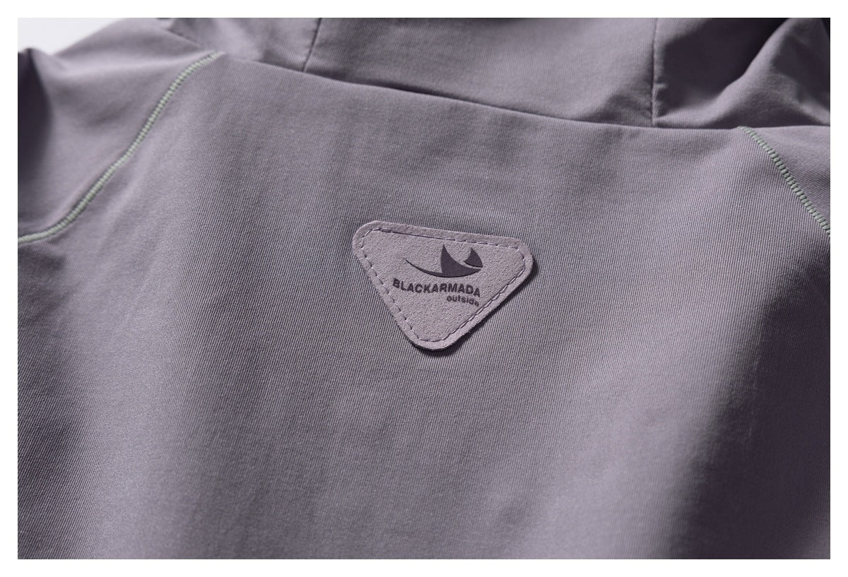 Close-up of a gray jacket with a triangular BLACKARMADA outside patch.