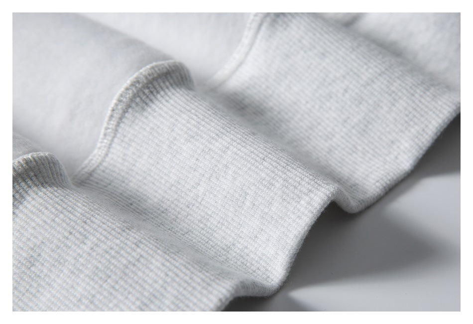 Close-up of the ribbed cuff on a light gray hoodie.