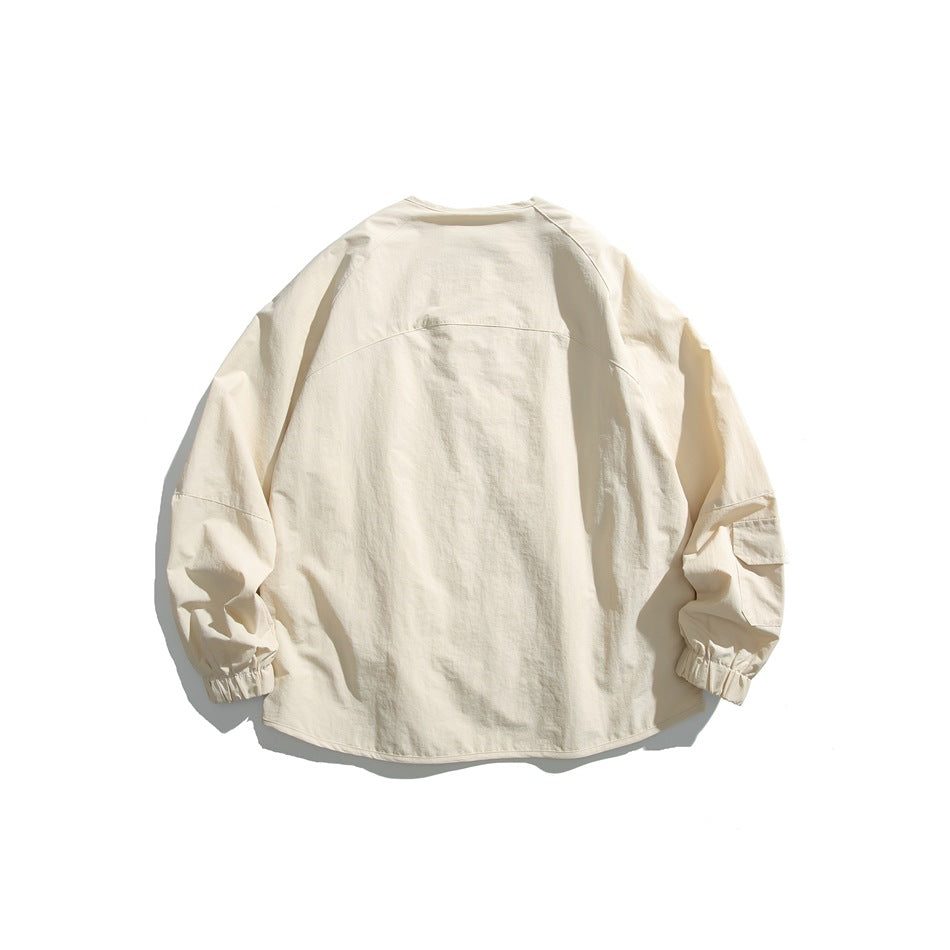 Back view of an ivory jacket with a curved yoke seam, raglan sleeves, and elastic cuffs.