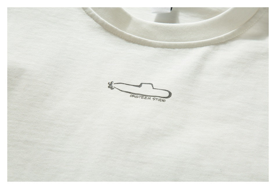 Close-up of a small dark outlined graphic and lettering printed on the chest of an off-white T-shirt.