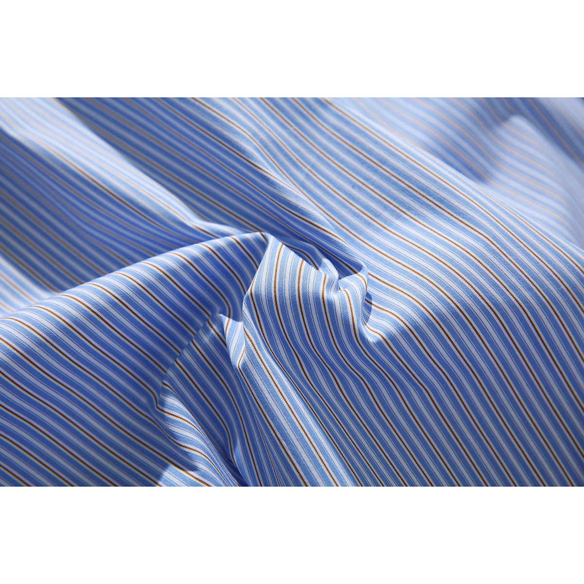 Close-up of blue fabric with narrow white and tan stripes, draped into folds.